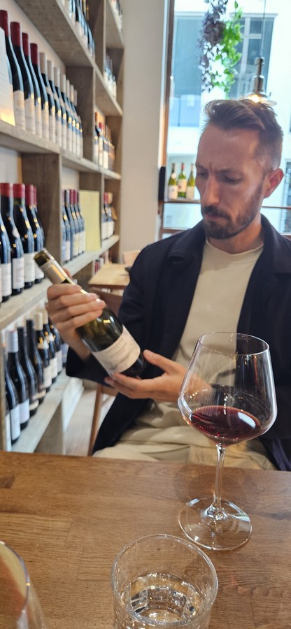 Adam tasting wine in a wine shop